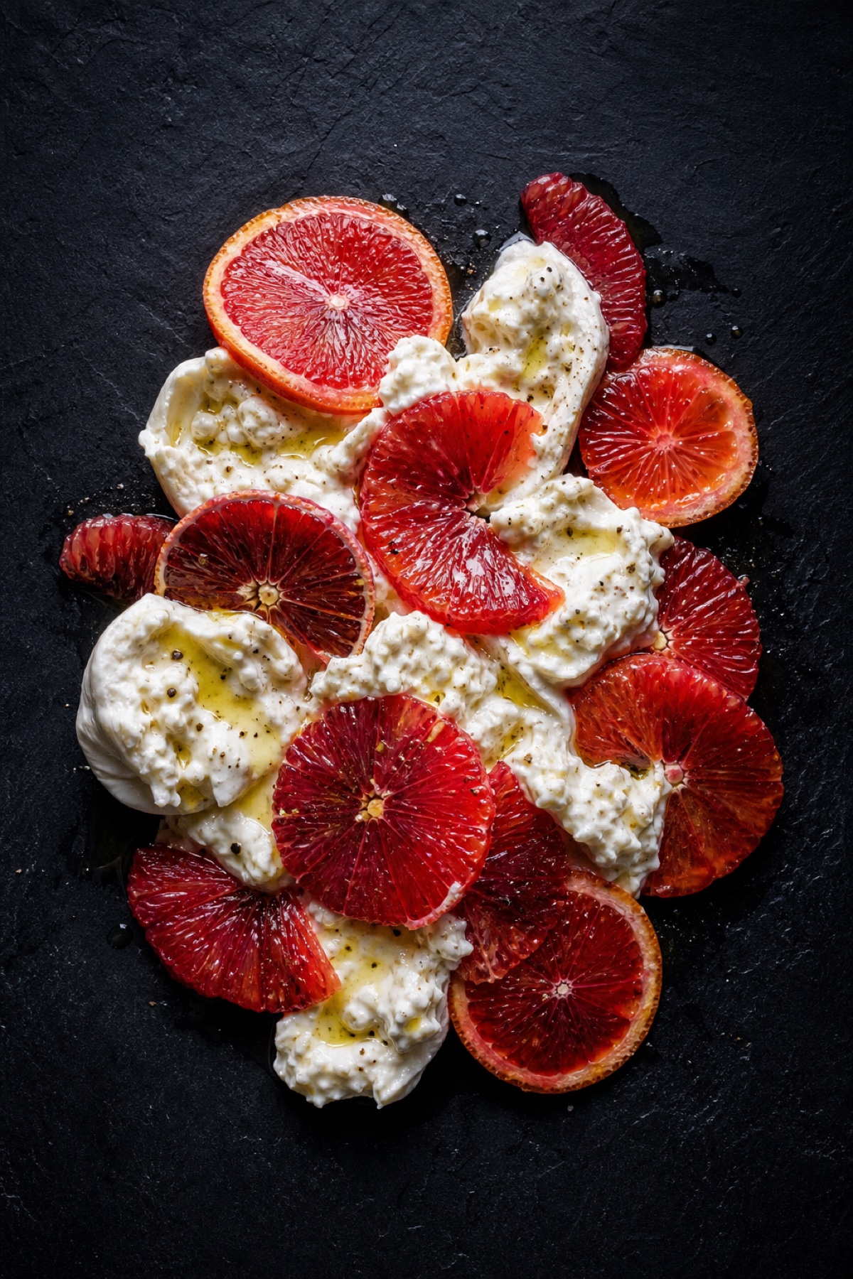 Blood orange and burrata salad, high-contrast overhead flat-lay on charcoal slate, vegetarian
